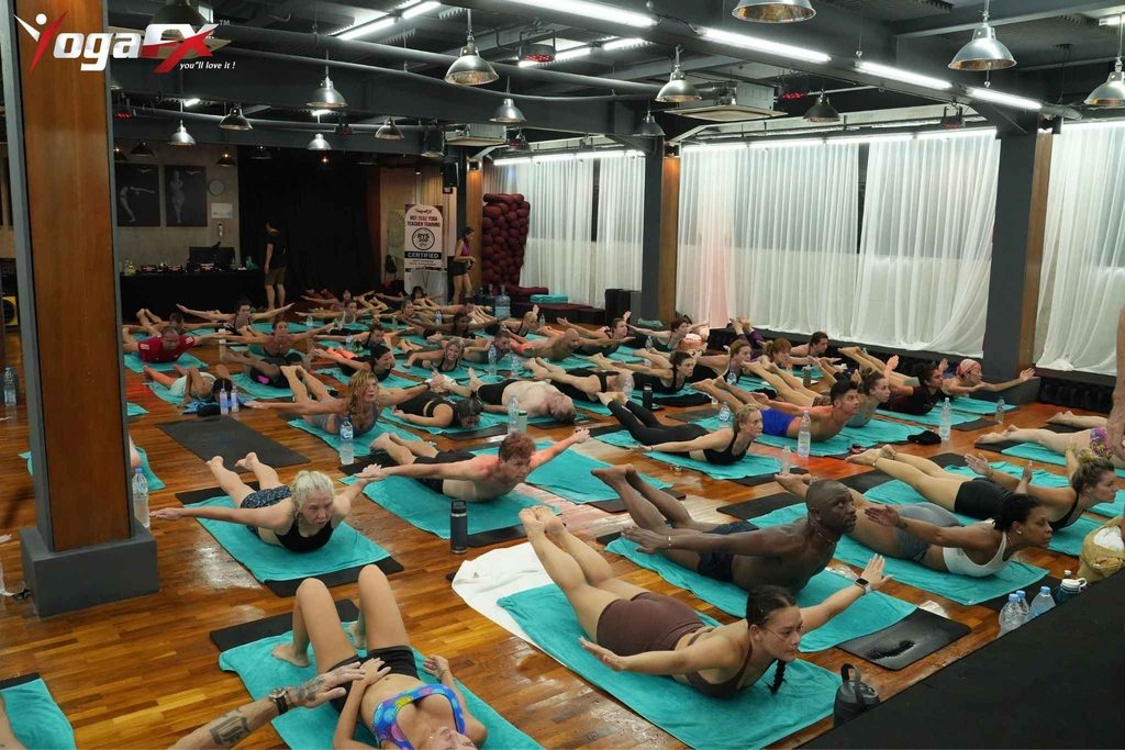 Practitioners doing the 26 and 2 original hot yoga sequence in a heated studio room.