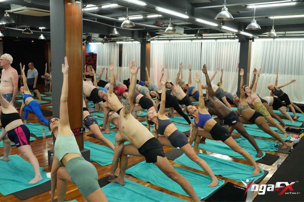Students practising 26 and 2 yoga in a heated studio, showing that calories burned in a 60 minute hot yoga class depend on effort and body weight