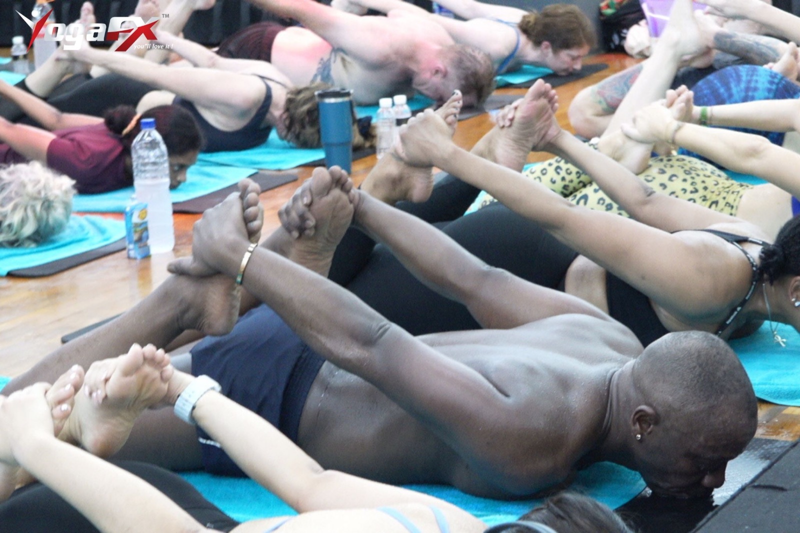 A row of students of varied ages and builds lying in the floor series of a heated 26 and 2 class