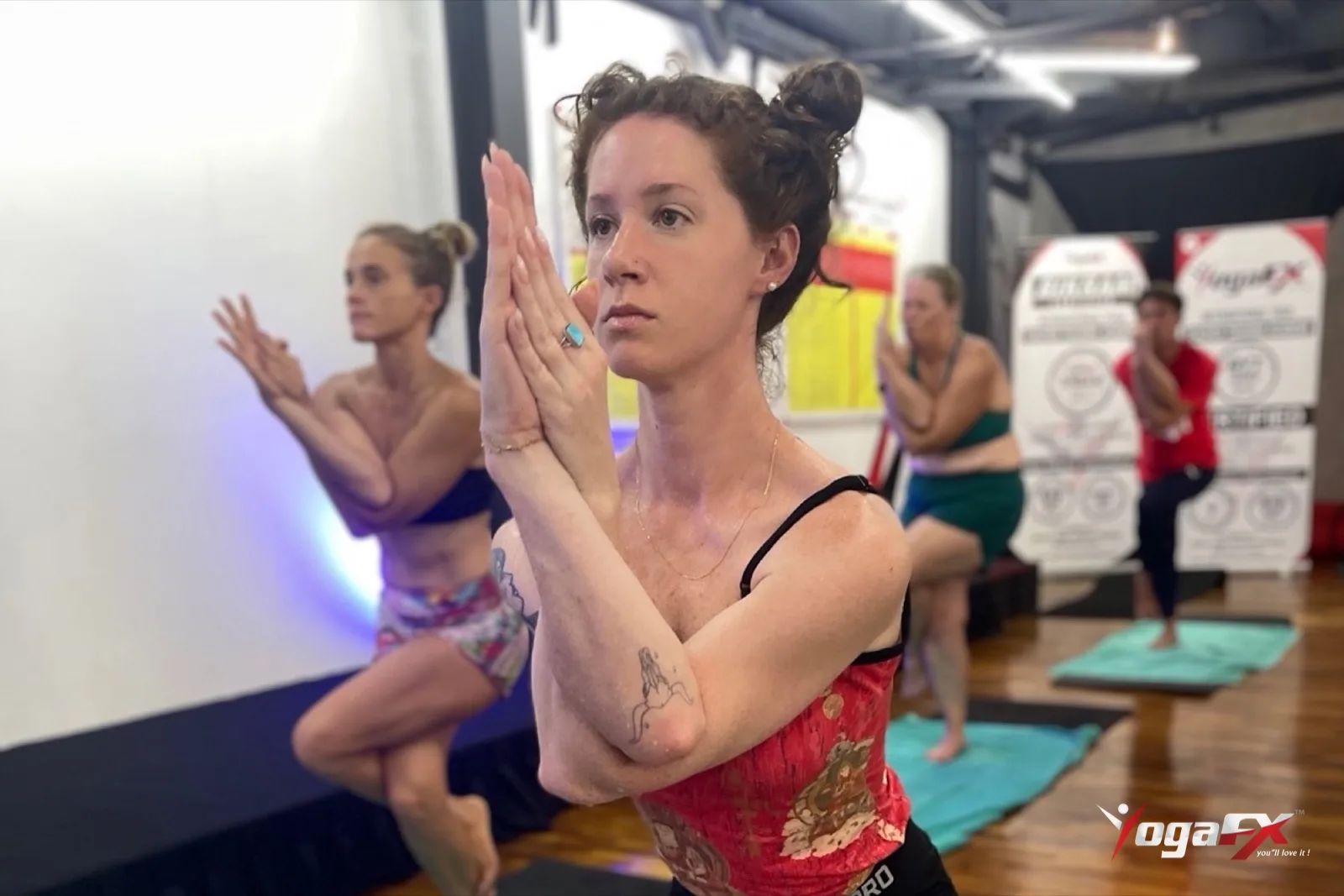 Student holding Eagle Pose in a hot 26 and 2 class, one of the balance postures in yoga for men over 50